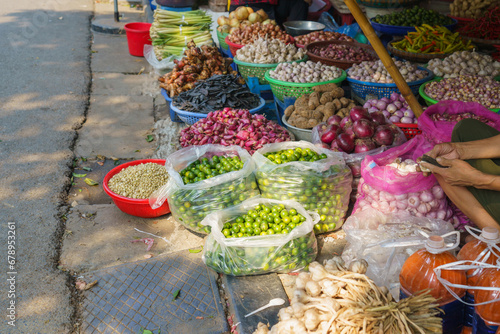 Baskets of different types of dried fruit, herbs, vegetables in an outdoor market on Hanoi street