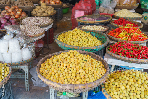 Baskets of different types of dried fruit, herbs, vegetables in an outdoor market on Hanoi street