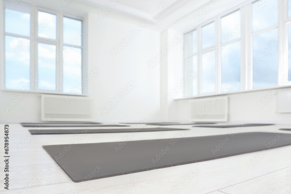 Spacious yoga studio with exercise mats and big windows, low angle view Spacious yoga studio with exercise mats and big windows, low angle view