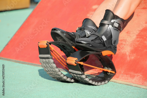 Woman with kangoo jumping boots outdoors, closeup