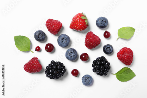 Many different fresh berries and mint leaves on white background, flat lay