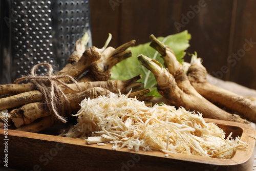 Photos Grated horseradish and roots on table, closeup