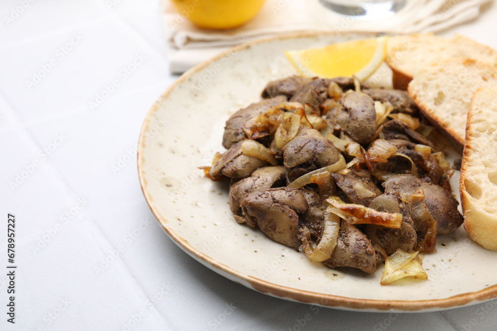 Tasty fried chicken liver with onion served on white tiled table, closeup. Space for text Tasty fried chicken liver with onion served on white tiled table, closeup. Space for text