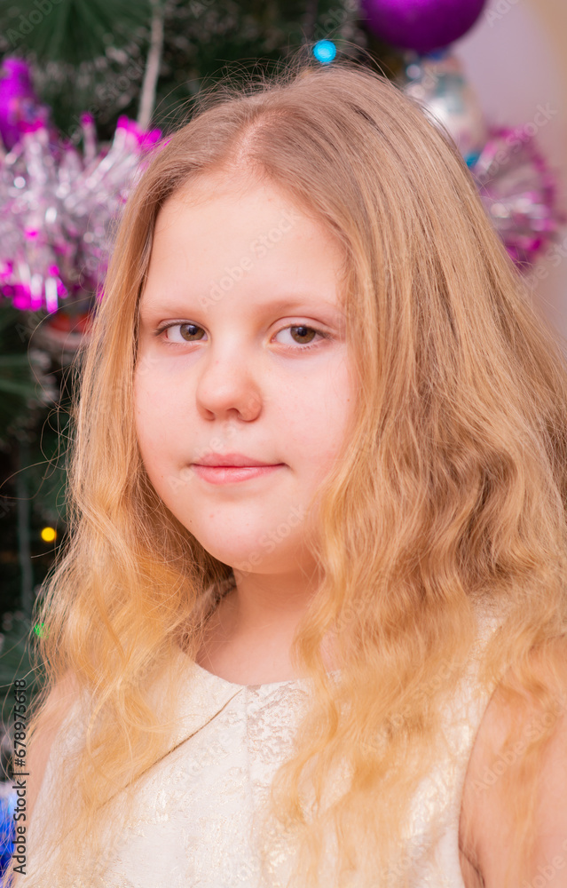 A beautiful elegant girl near the Christmas tree in the New Year. Holiday. New Year. The child is a model. A beautiful elegant girl near the Christmas tree in the New Year. Holiday. New Year. The child is a model.