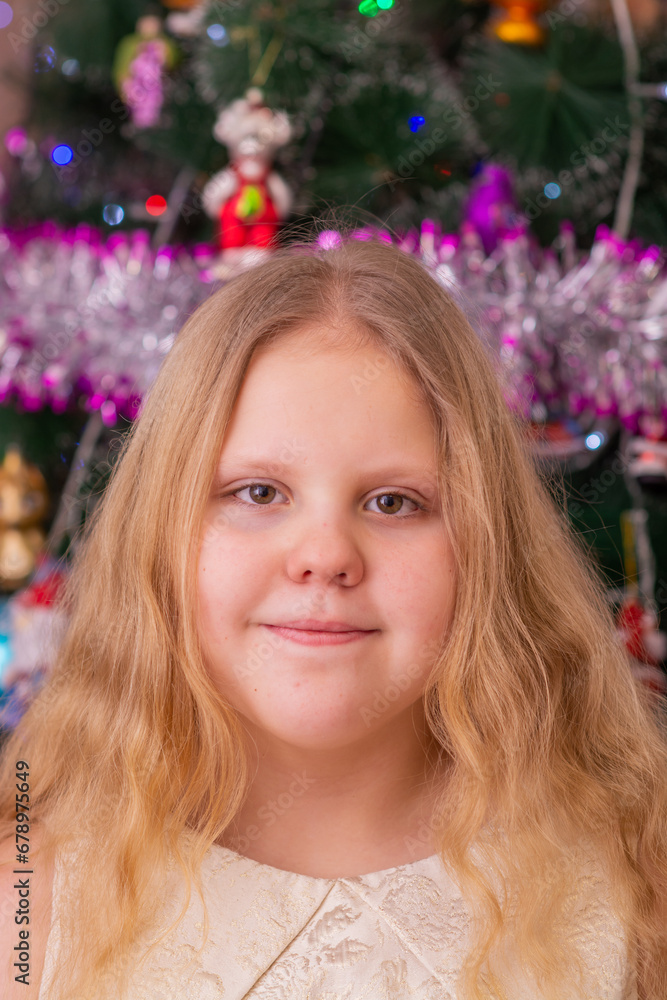A beautiful elegant girl near the Christmas tree in the New Year. Holiday. New Year. The child is a model. A beautiful elegant girl near the Christmas tree in the New Year. Holiday. New Year. The child is a model.