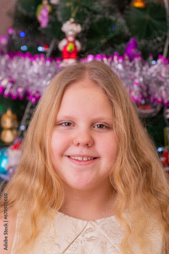 A beautiful elegant girl near the Christmas tree in the New Year. Holiday. New Year. The child is a model. A beautiful elegant girl near the Christmas tree in the New Year. Holiday. New Year. The child is a model.