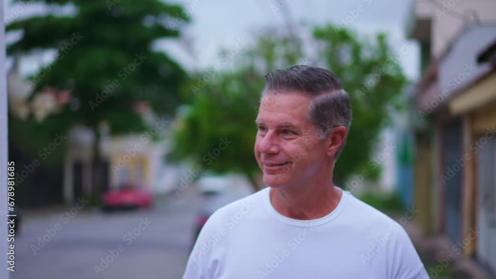 Happy older man walking in city street smiling. middle-age male caucasian person walks forward toward camera Happy older man walking in city street smiling. middle-age male caucasian person walks forward toward camera