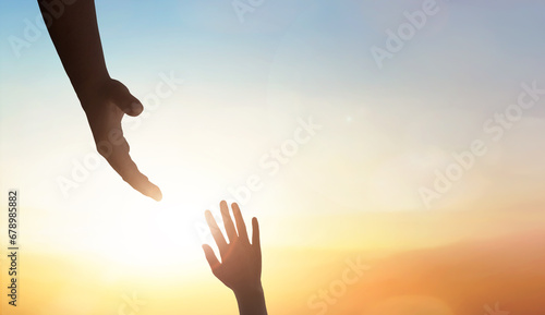 Hand reaching out to help someone on sunset sky background. photo