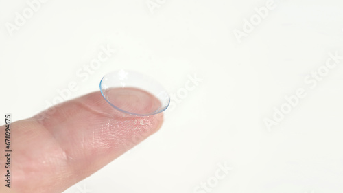 Close up of a hand holding a soft contact lens