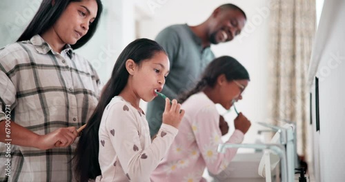 Parents, girl kids and brushing hair in bathroom, support and hygiene for teeth, mouth and love in morning. Dad, mother and daughter kids with toothbrush, together and helping hand in family house photo