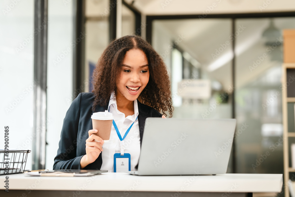 African American businesswoman, focused on her work on a laptop, possibly managing industrial production tasks. African American businesswoman, focused on her work on a laptop, possibly managing industrial production tasks.