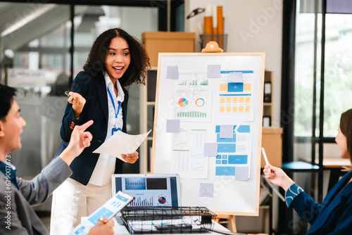 diverse team of professionals engaged in a website graphic design board meeting, sharing opinions on UX and UI design elements. Asian man, African American people, black, afro, caucasian female photo