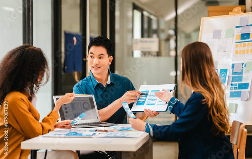 diverse team of professionals engaged in a website graphic design board meeting, sharing opinions on UX and UI design elements. Asian man, African American people, black, afro, caucasian female © makibestphoto