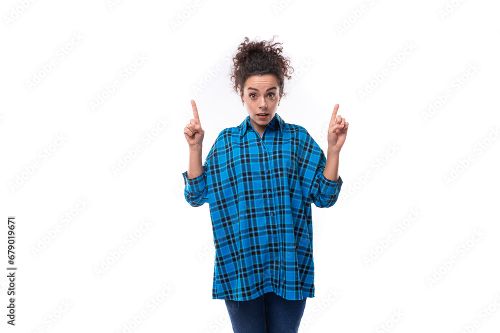 a young beautiful European woman with curly hair is dressed in a blue checkered shirt and actively gesticulates. advertising concept a young beautiful European woman with curly hair is dressed in a blue checkered shirt and actively gesticulates. advertising concept