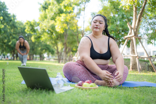 Happy plus size asian woman practicing yoga in garden. Healthy lifestyle and relaxation concept.Young Asian Girl doing yoga in the park.