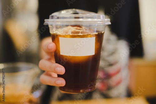 Owner  serving a plastic cup of ice coffee, Owner of coffee shop service customer, 