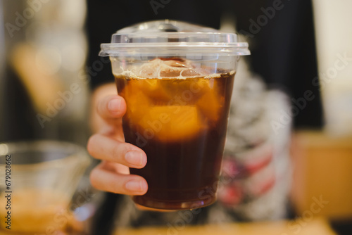 Owner  serving a plastic cup of ice coffee, Owner of coffee shop service customer, 
