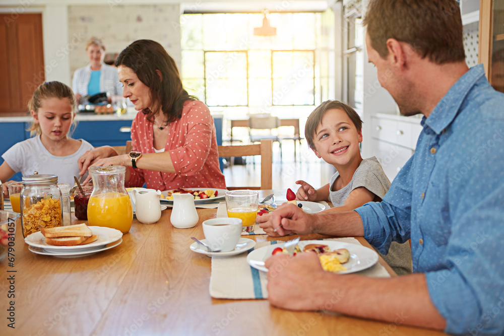 Food, breakfast and weekend with a family in the dining room of their home together for health or nutrition. Mother, father and children in the morning, eating at their apartment table for bonding