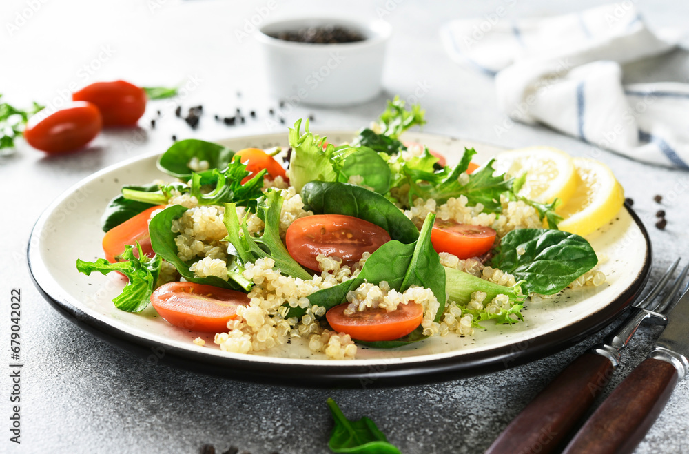 Salad with quinoa tomatoes and spinach on a light background Salad with quinoa tomatoes and spinach on a light background