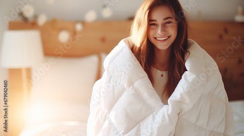 Woman with a white warm duvet quilt in bedroom preparing for cold days of winter at home photo