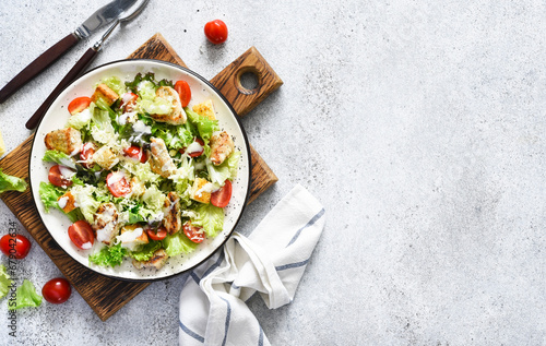 Caesar salad with chicken, cheese and tomatoes