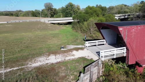 Holliwell covered bridge in Madison County Iowa. Aerial, rotating pan shot of the bridge and stream underneath. Bright sunny morning shot of the area. photo