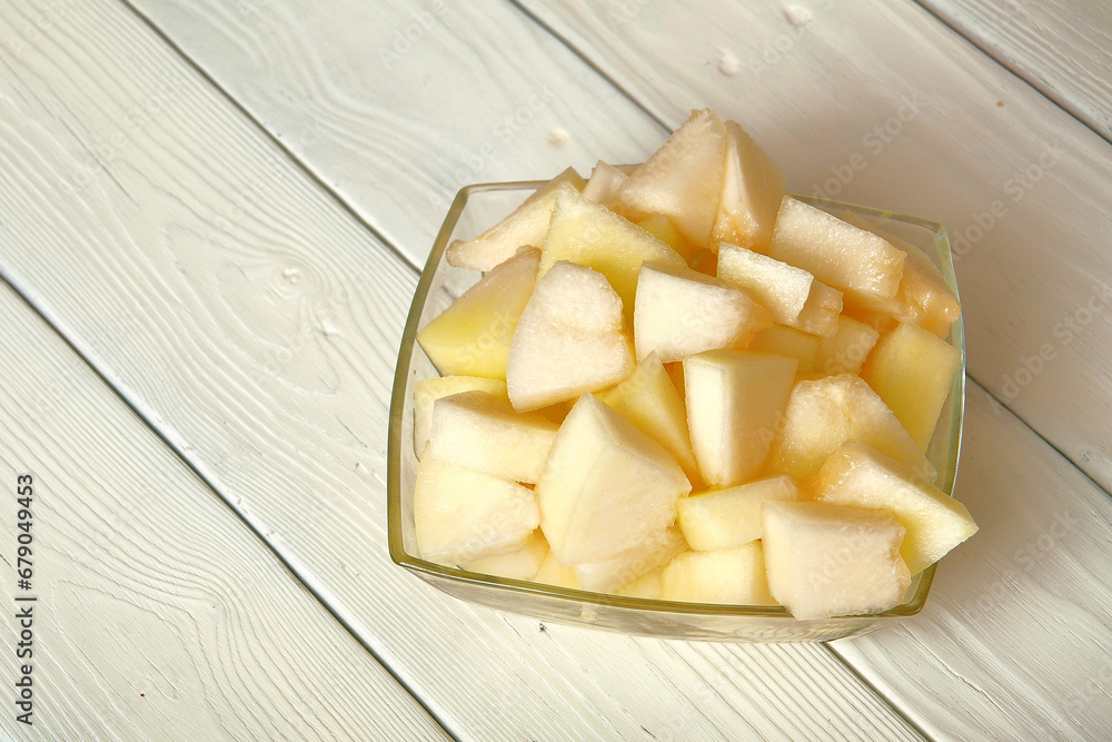 Cut the melon into pieces.on the table is a soft melon, sweet watermelon, cut into large chunks.space for text.table decoration.wooden white background.The concept of the dish.Close-up Cut the melon into pieces.on the table is a soft melon, sweet watermelon, cut into large chunks.space for text.table decoration.wooden white background.The concept of the dish.Close-up