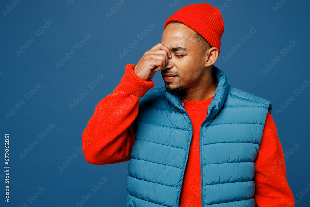 Φωτογραφία Young sad sick ill man of African American ethnicity wear padded vest red hat ke