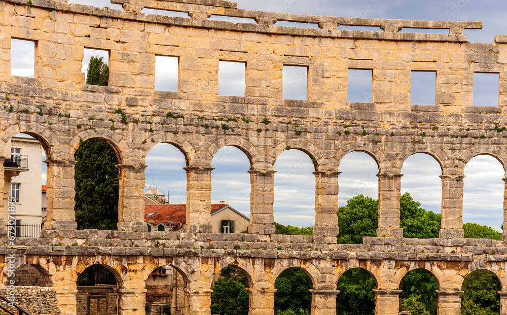 ancient wall with arches and windows of historical building, ancient architecture outdoor , roman arena in Pula