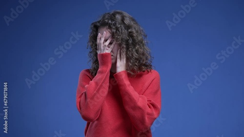 Woman covering face with regret, anxious preoccupied 20s person feeling anguish and annoyance during mental pressure