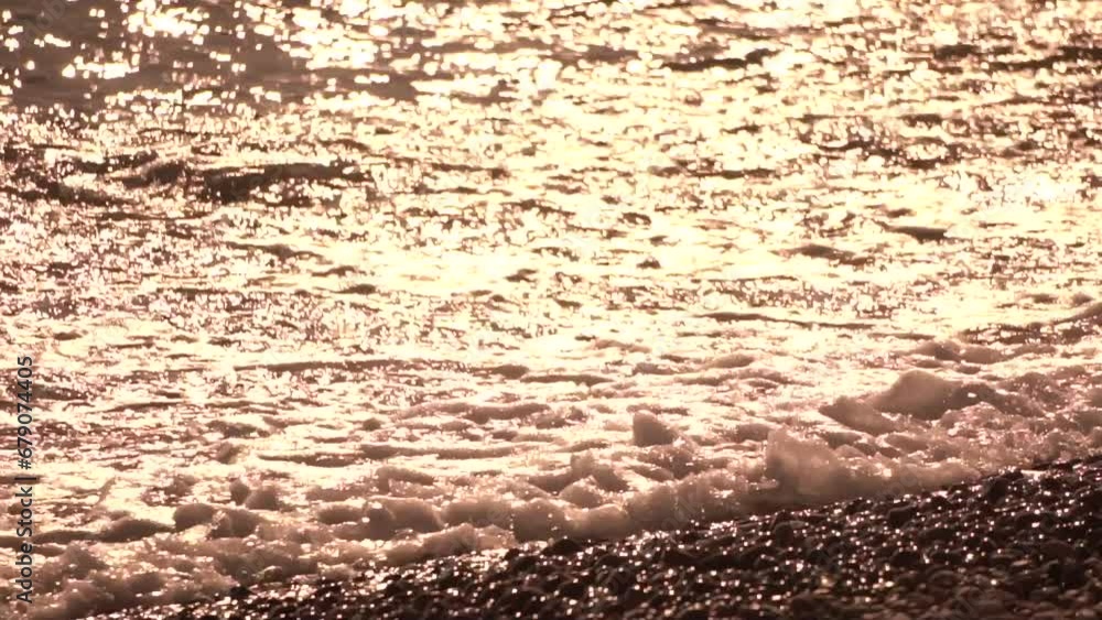 Sea beach wave. Sea waves with soft, foamy waters washing multicolored pebbles on a beach during sunset. Nobody. Holiday recreation concept. Abstract nautical summer ocean sunset nature Slow motion Sea beach wave. Sea waves with soft, foamy waters washing multicolored pebbles on a beach during sunset. Nobody. Holiday recreation concept. Abstract nautical summer ocean sunset nature Slow motion