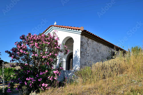 white Greek-Orthodox chapel with a flowered leander - Varos Village, Lemnos island, Greece, Aegean Sea photo