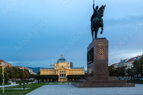 Zagreb, Croatia 10-10-2023 The statue of first king of Croatia King Tomislav in Zagreb during a colourful sunrise located on the Lenuci Horseshoe in the lower town on the square near the train station photo