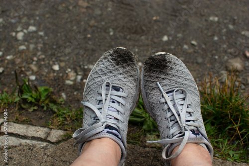 Female legs in sneakers  relaxing outdoors on a rainy summer day  traveling through the mountains