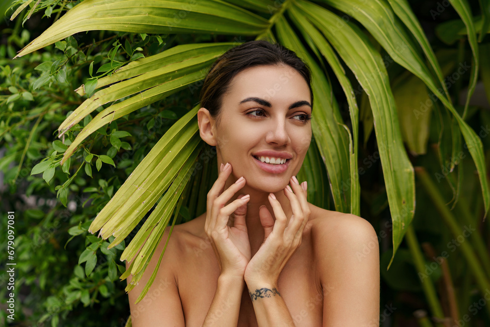 Beautiful woman with perfect makeup posing on green palm trees background. Beauty concept. Close up photo. Beautiful woman with perfect makeup posing on green palm trees background. Beauty concept. Close up photo.