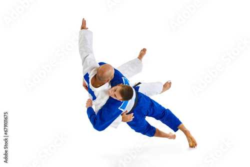 Portrait of two athletic, strong men, professional judokas, fighters showing their skills while competition isolated white background. photo