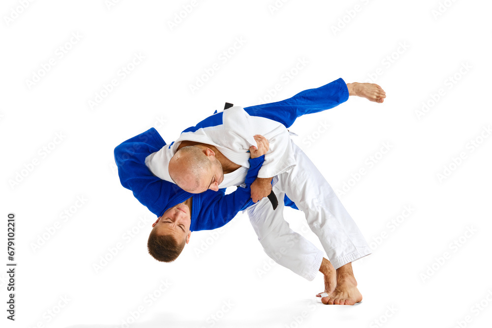 Two Caucasian karate fighters in white and blue kimono with black belts fighting isolated white background. Concept of combat sport.