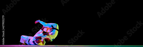 Banner. Two men Judoist training, fighting showing technical skill in neon light isolated black studio background. Copy space for ad, text