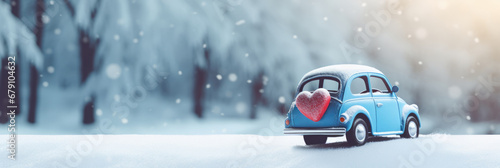 Blue toy car with red heart on winter snowy background photo