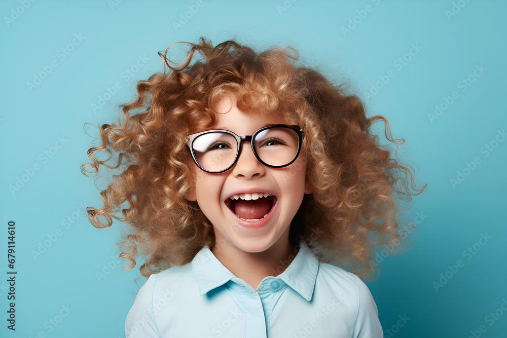 Closeup Portrait Of Funny Cute Little Girl in glasses Laughing At Camera, Posing Over blue Background In Studio, Free Space