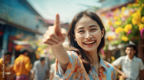 Wallpaper Mural A happy smiling woman brushes her cheeks wearing a blue floral shirt. and pointing the finger at the empty space during the Songkran festival Torontodigital.ca