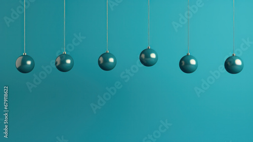 Row of color christmas balls hanging on strings over blue background © PaulShlykov
