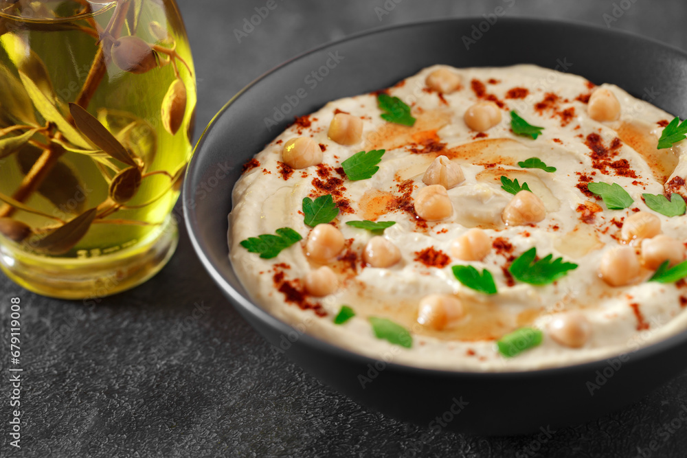 Hummus with oil, chickpeas and spices in bowl, selective focus Hummus with oil, chickpeas and spices in bowl, selective focus