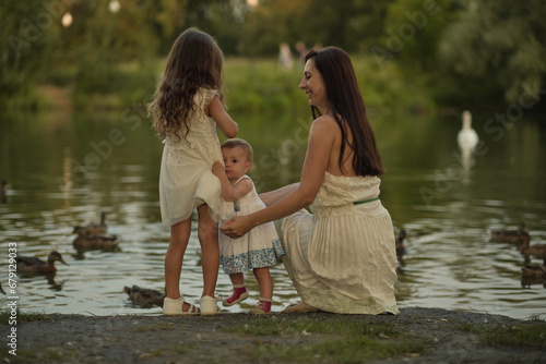 A spontaneous display of affection between a mother and her children, set against a backdrop of nature's bounty, this image captures the essence of familial intimacy and nurturing aspect of parenting