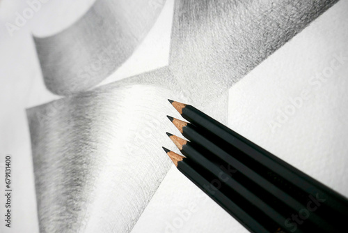 Black drawing pencils on white paper with hand drawn geometric shapes