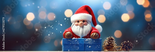 Cute Toy Santa Claus holding a gift box standing in front of the Merry Christmas lighting background with lighting decoration © IlluGrapix