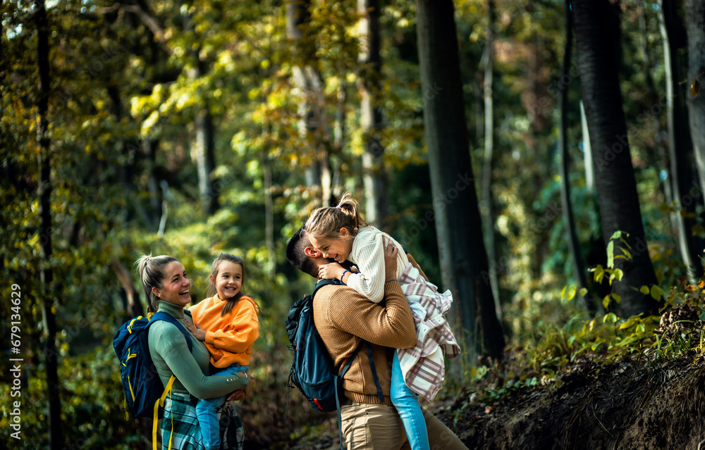 Smiling family of four enjoying hiking in trough forest. Smiling family of four enjoying hiking in trough forest.