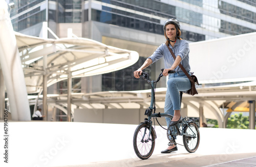 Smart businesswoman wear safety helmet ride bicycle in downtown smile. Environmentalist cycling to work reduce carbon footprint global warming. Bike is eco friendly transportation green energy vehicle