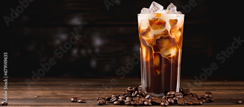 Iced coffee with cream and beans on a rustic wooden table Cold drink on black background with space for text Copy space image Place for adding text or design photo