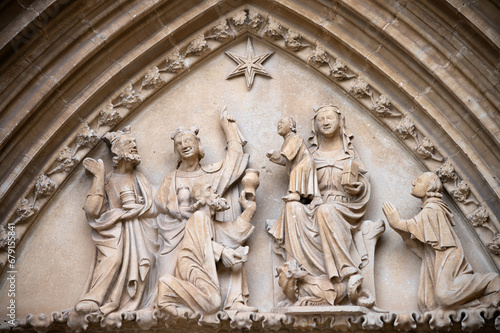 Vista del tímpano con la escena de la adoración de los Reyes Magos en el arco gótico de entrada a la iglesia de Ujué, Navarra, España.